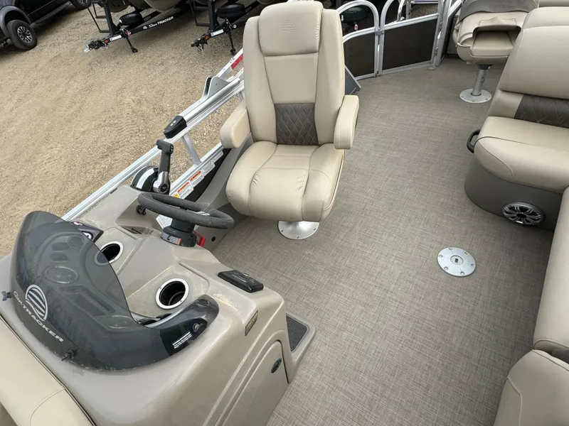 Slide: The Image of 2023 Sun Tracker SportFish 22 DLX interior with beige seating and steering console. - 11