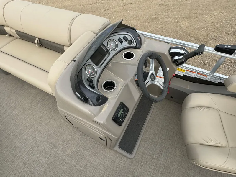 Slide: The Image of 2023 Sun Tracker SportFish 22 DLX boat interior with beige seating and modern dashboard. - 12