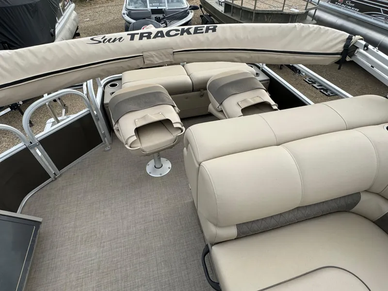 Slide: The Image of 2023 Sun Tracker SportFish 22 DLX pontoon boat interior with beige seating and fishing chairs. - 15