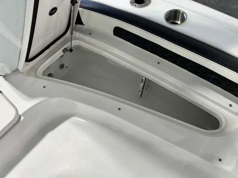 Slide: The Image of 2025 Tidewater 2300 Carolina Bay boat storage compartment with cup holder and sleek design. - 10