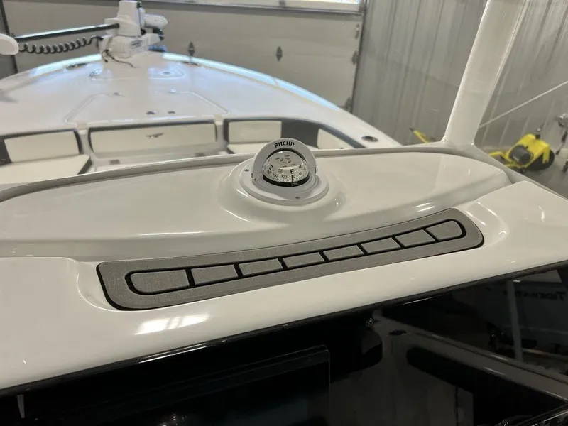 Slide: The Image of 2025 Tidewater 2300 Carolina Bay boat dashboard with compass and control panel. - 19