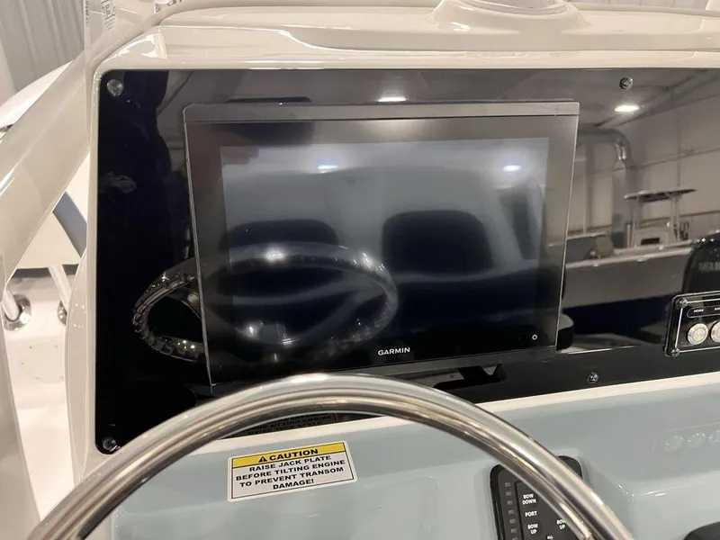 Slide: The Image of 2025 Tidewater 2300 Carolina Bay boat dashboard with Garmin display and steering wheel. - 21
