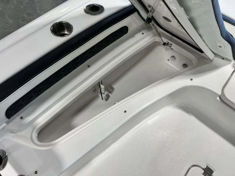 Slide: The Image of 2025 Tidewater 2300 Carolina Bay boat storage compartment, open lid, sleek white interior design. - 8
