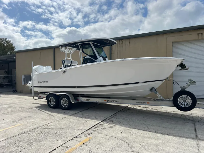 Slide: The Image of 2025 Blackfin 272 CC boat on trailer, parked outdoors under cloudy sky. - 18