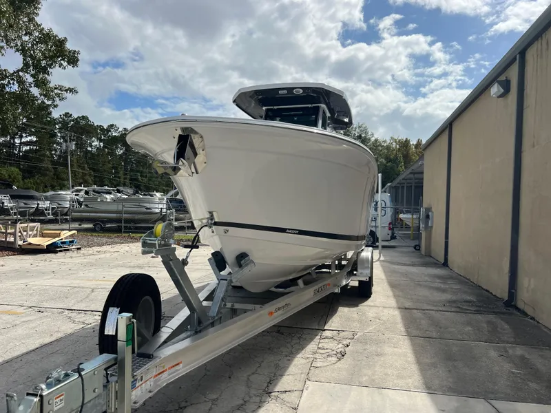 Slide: The Image of 2025 Blackfin 272 CC boat on trailer, parked outdoors under cloudy sky. - 21