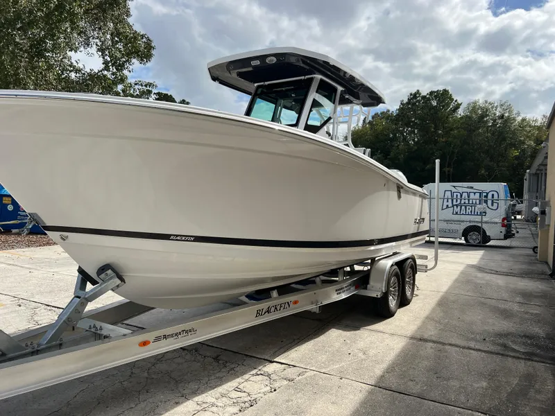 Slide: The Image of 2025 Blackfin 272 CC boat on trailer, parked outdoors under cloudy sky. - 22