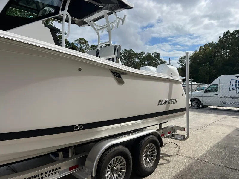 Slide: The Image of 2025 Blackfin 272 CC boat on trailer, parked outdoors. - 24