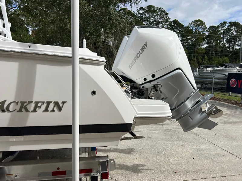 Slide: The Image of 2025 Blackfin 272 CC boat with Mercury outboard engine, parked outdoors. - 25