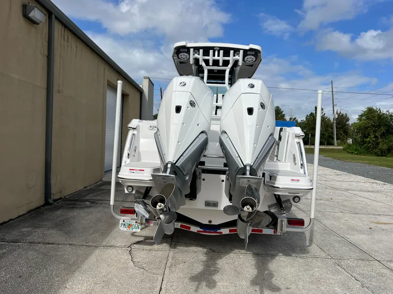 Slide: The Image of 2025 Blackfin 272 CC boat with dual outboard engines, parked outdoors. - 27