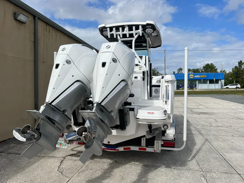 Slide: The Image of 2025 Blackfin 272 CC boat with dual outboard motors in a parking lot. - 28