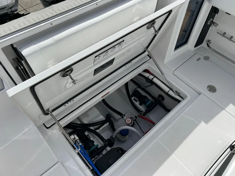 Slide: The Image of 2025 Blackfin 272 CC boat storage compartment with open hatch, showcasing internal wiring and components. - 36
