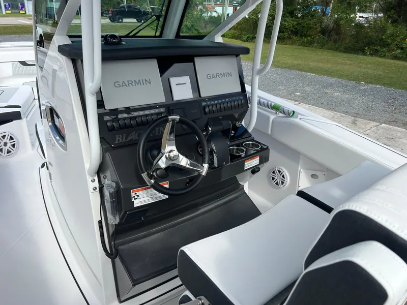 Slide: The Image of 2025 Blackfin 272 CC boat cockpit with Garmin navigation system and sleek steering wheel. - 48