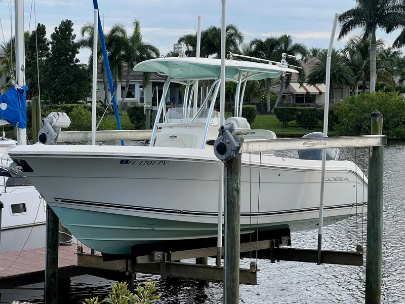 Slide: The Image of 2015 Cobia 237 Center Console boat docked by waterfront homes. - 1