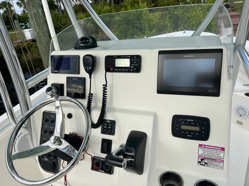 Slide: The Image of 2015 Cobia 237 Center Console boat dashboard with steering wheel and navigation equipment. - 13
