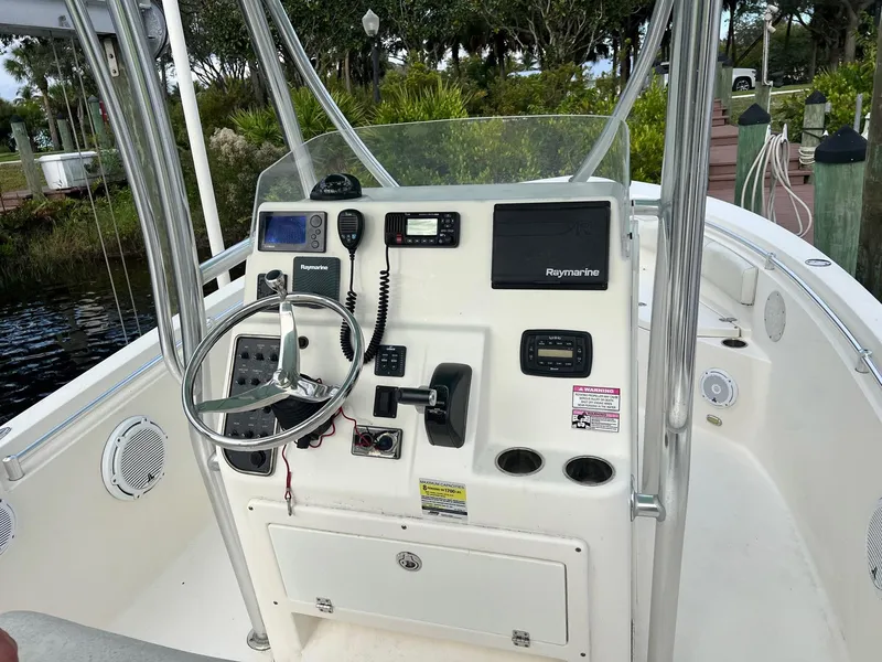 Slide: The Image of 2015 Cobia 237 Center Console boat dashboard with steering wheel and navigation equipment. - 16