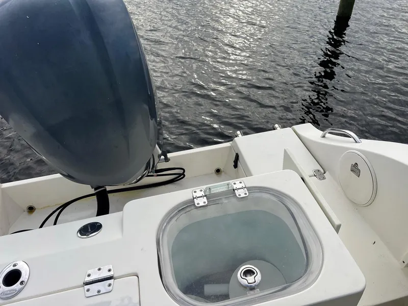 Slide: The Image of 2015 Cobia 237 Center Console boat with outboard motor and livewell on water. - 22