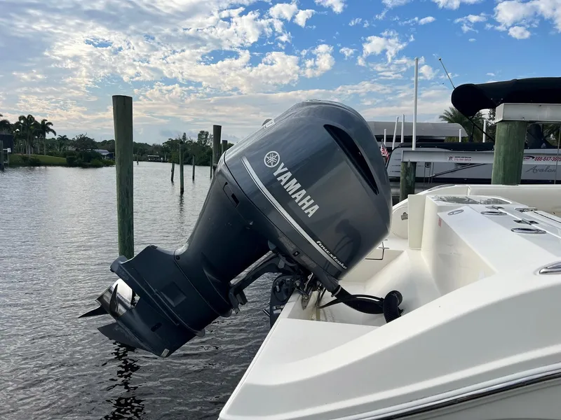 Slide: The Image of 2015 Cobia 237 Center Console with Yamaha outboard motor on a calm waterway. - 24