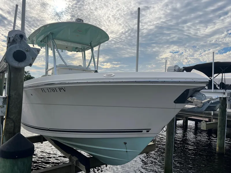 Slide: The Image of 2015 Cobia 237 Center Console boat docked under cloudy sky. - 4
