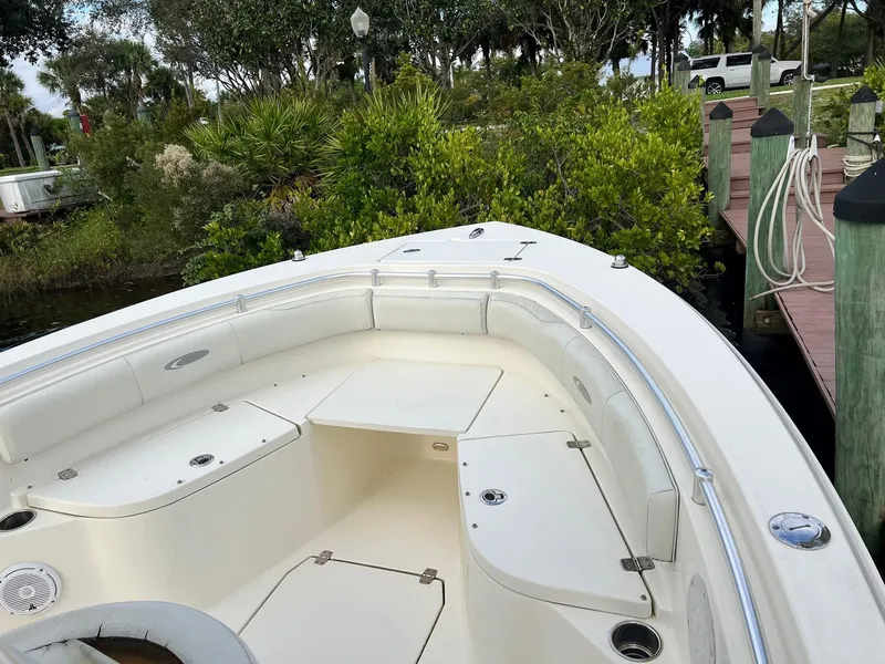 Slide: The Image of 2015 Cobia 237 Center Console boat docked near lush greenery. - 7