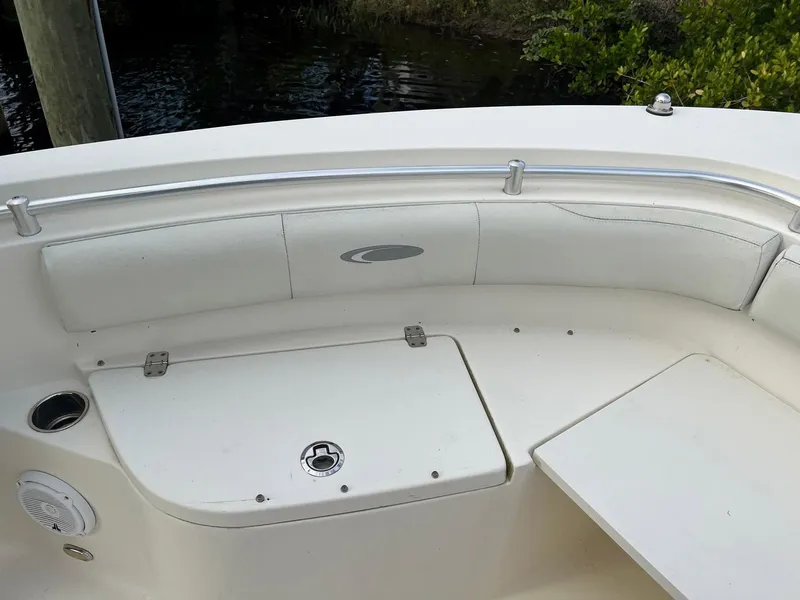 Slide: The Image of 2015 Cobia 237 Center Console boat interior with white seating and storage compartment. - 8