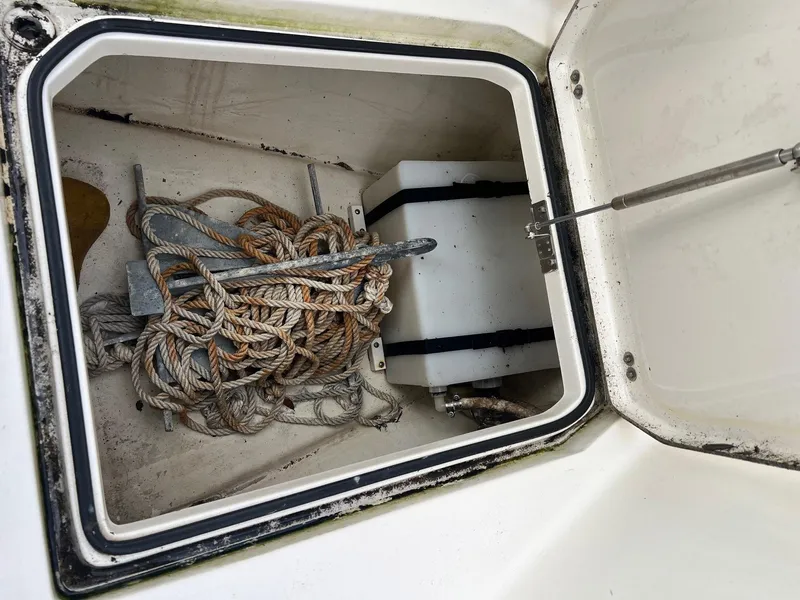 Slide: The Image of Open storage compartment on 2015 Cobia 237 Center Console with ropes and anchor. - 9