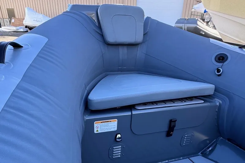 Slide: The Image of 2025 Highfield Classic 460 boat interior with cushioned seating and storage compartment. - 10