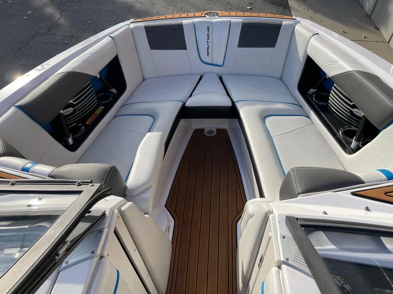 Slide: The Image of 2015 Nautique Super Air G23 boat interior with white seating and wood flooring. - 11