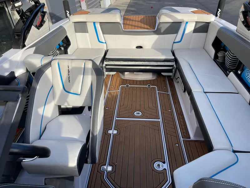 Slide: The Image of 2015 Nautique Super Air G23 interior with white and gray seating, teak flooring. - 12