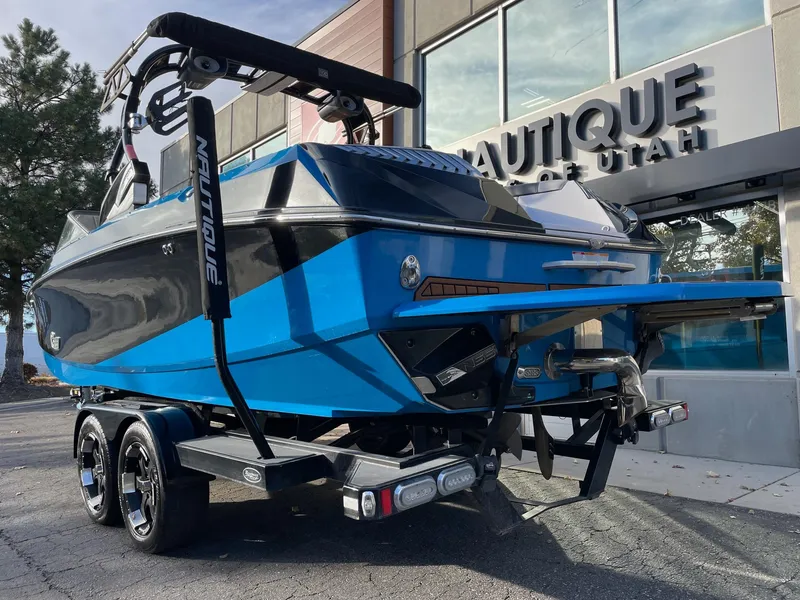 Slide: The Image of 2015 Nautique Super Air G23 boat in blue, parked outside dealership. - 3