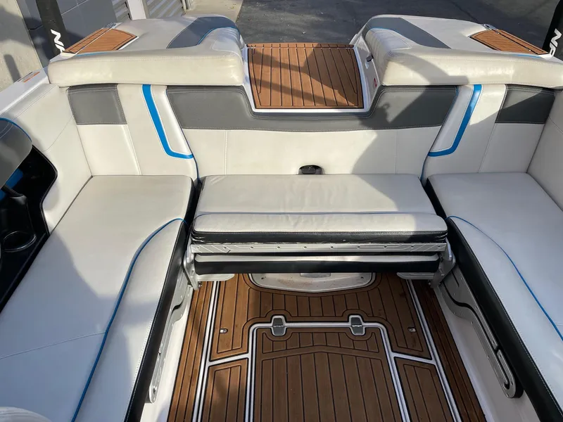 Slide: The Image of 2015 Nautique Super Air G23 interior with white seating and teak flooring. - 8