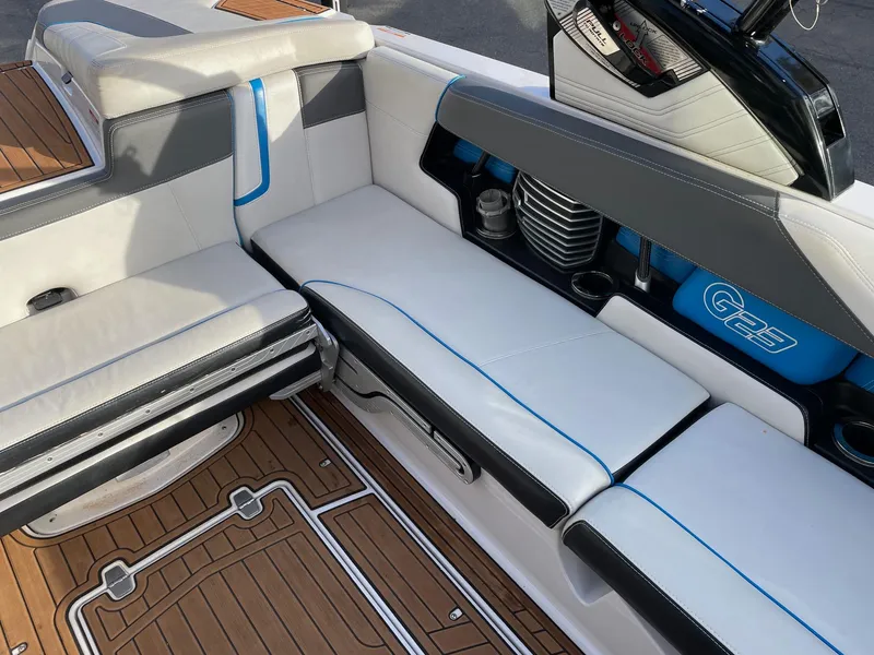 Slide: The Image of 2015 Nautique Super Air G23 interior with white and gray seating, blue accents, and teak flooring. - 9