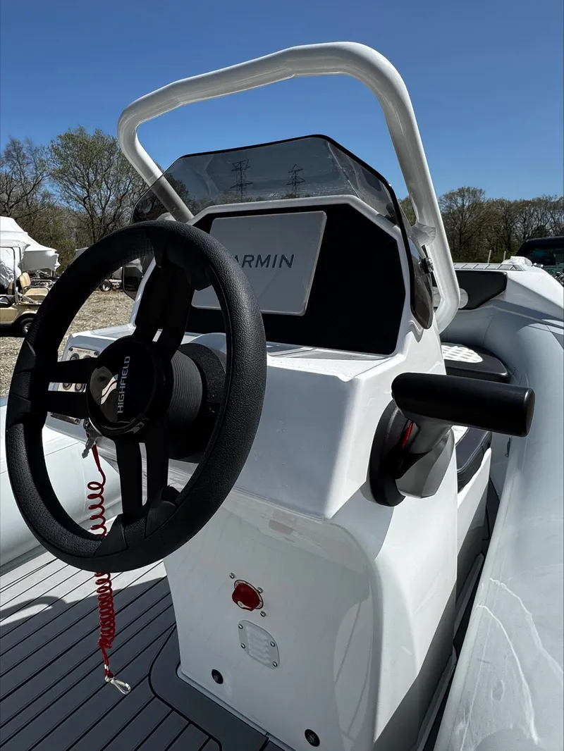 Slide: The Image of 2025 Highfield Sport 420 boat console with steering wheel and Garmin display. - 13