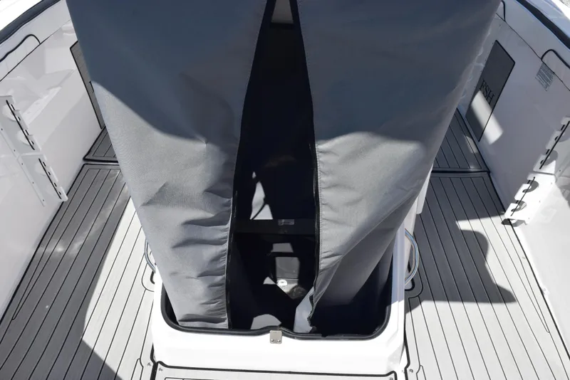 Slide: The Image of 2025 Yamaha Boats 255 FSH Sport E deck with storage compartment and cover. - 17