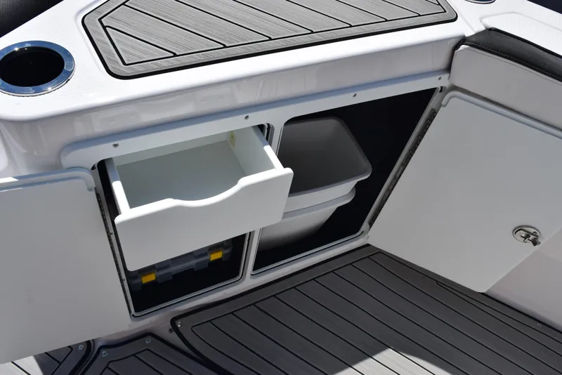 Slide: The Image of 2025 Yamaha Boats 255 FSH Sport E storage compartments with open drawer and cabinet. - 19