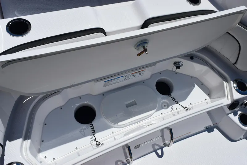 Slide: The Image of Yamaha Boats 2025 255 FSH Sport E storage compartment with cup holders and secure latch. - 27