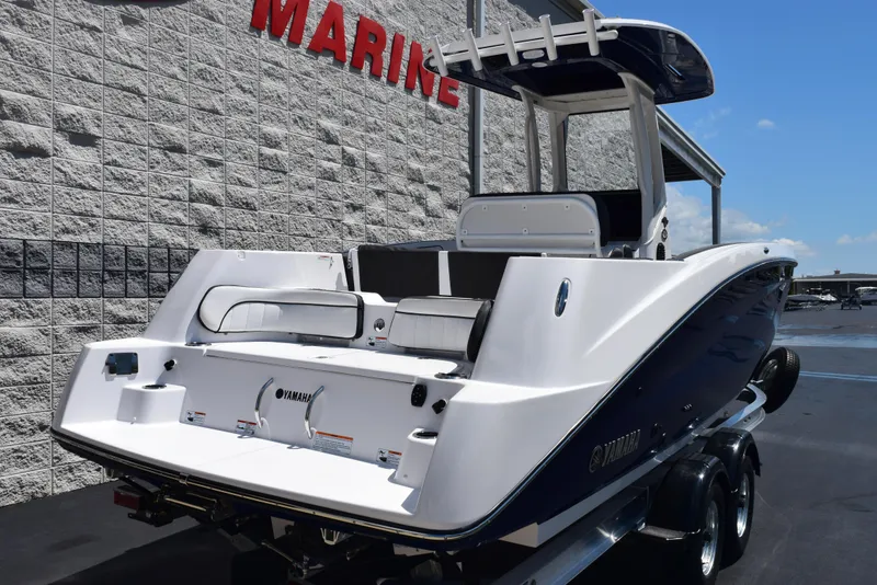 Slide: The Image of 2025 Yamaha Boats 255 FSH Sport E, sleek design, parked at a marine dealership. - 3