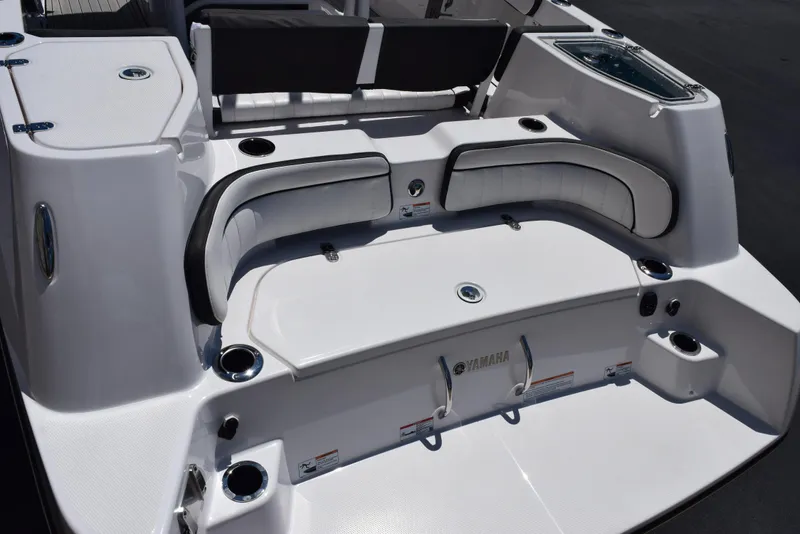 Slide: The Image of 2025 Yamaha Boats 255 FSH Sport E, sleek white deck with seating and cup holders. - 6