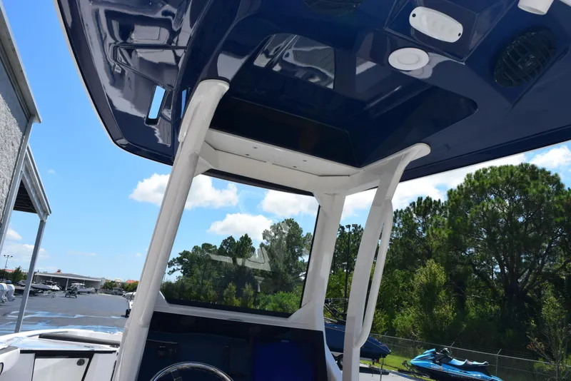 Slide: The Image of 2025 Yamaha Boats 255 FSH Sport E interior view with blue canopy and steering console. - 9