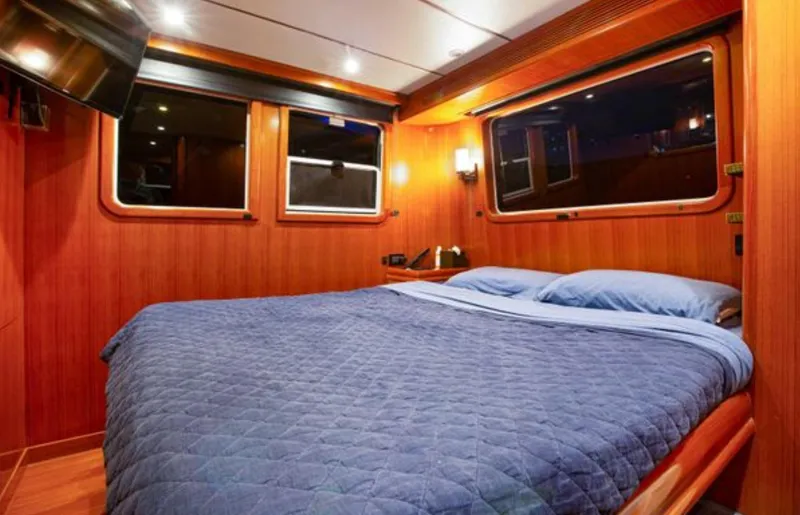 Slide: The Image of Luxurious cabin interior of 2009 Nordhavn 76 yacht with cozy bed and wooden paneling. - 14