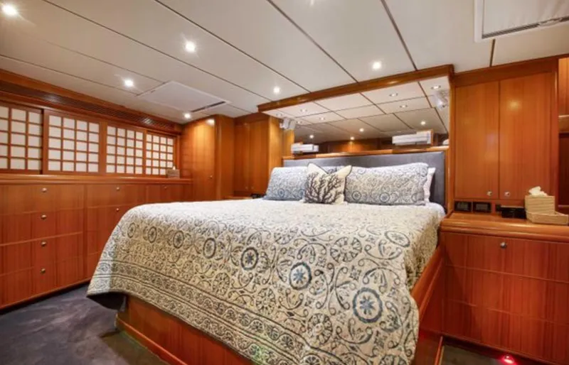 Slide: The Image of Luxurious 2009 Nordhavn 76 yacht bedroom with elegant wood paneling and patterned bedding. - 16