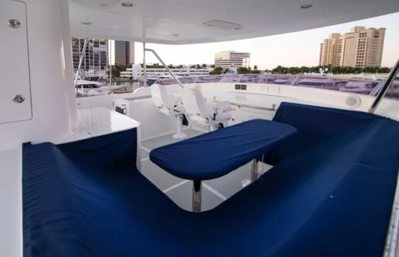 Slide: The Image of Luxurious 2009 Nordhavn 76 yacht deck with blue seating and cityscape view. - 5