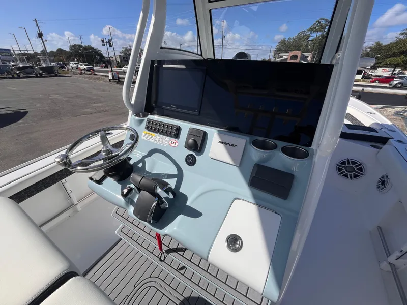 Slide: The Image of 2025 Tidewater 3100 Carolina Bay boat console with steering wheel and controls. - 10