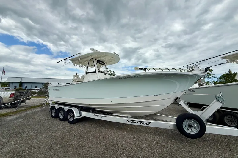 The Image of 2022 Regulator 28 boat on trailer under cloudy sky. - 0