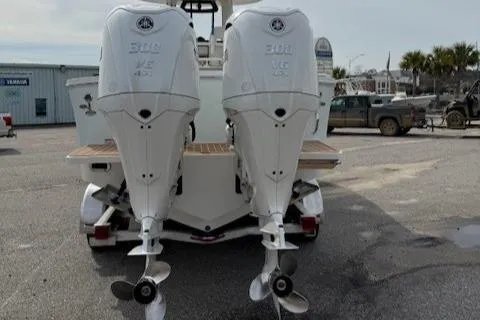 Slide: The Image of 2022 Regulator 28 boat with twin 300 horsepower outboard engines, parked in a lot. - 12