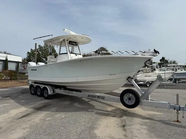 Slide: The Image of 2022 Regulator 28 boat on a Sport Trail trailer in a parking area. - 3