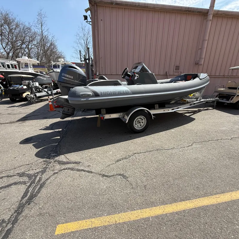 Slide: The Image of 2025 Highfield Sport 520 boat on trailer, parked outdoors near a building. - 1