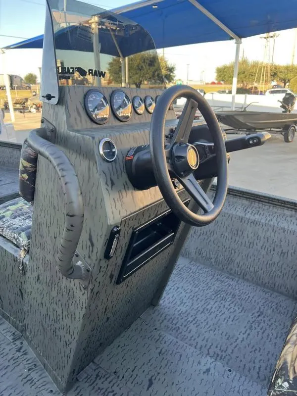 Slide: The Image of 2025 War Eagle 961 Blackhawk boat console with steering wheel and gauges. - 14