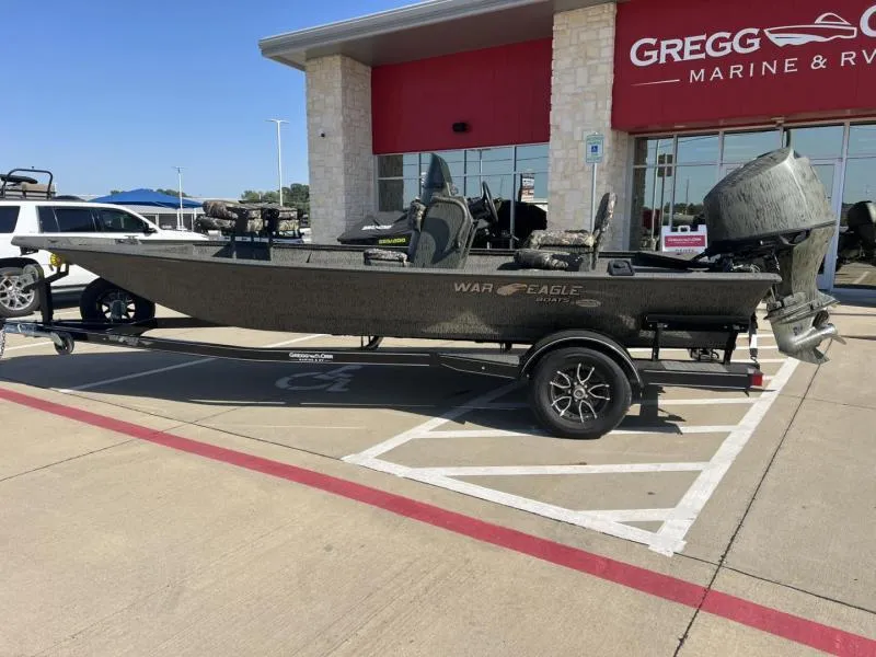 Slide: The Image of 2025 War Eagle 961 Blackhawk boat on trailer outside Gregg Marine & RV dealership. - 2