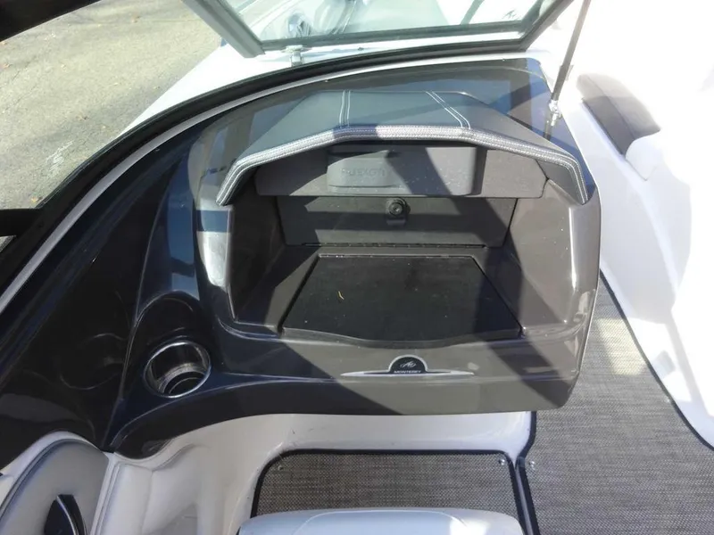 Slide: The Image of 2021 Monterey 224FS boat interior with open storage compartment and cup holder. - 15