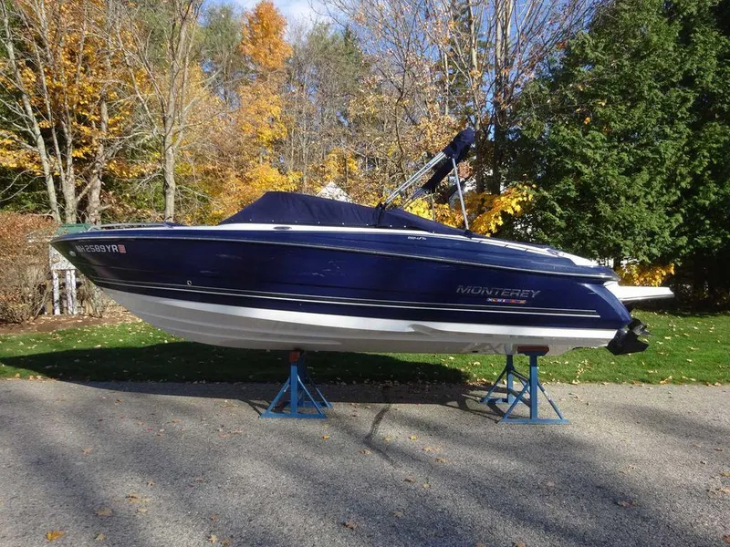 Slide: The Image of 2021 Monterey 224FS boat on stands, surrounded by autumn trees. - 23